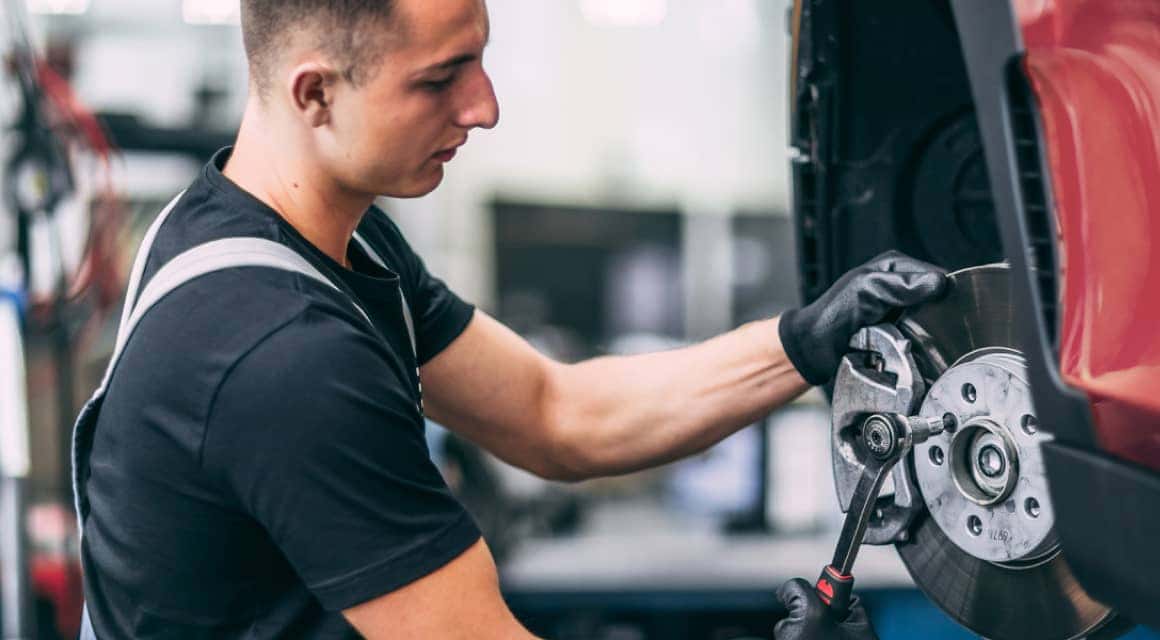 MINI service technician working on vehicle brakes