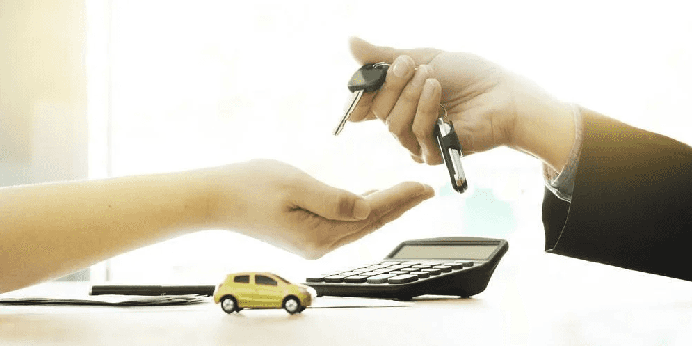 A person holding their hand out, about to receive car keys from another