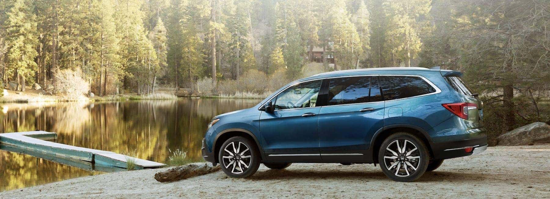 A Honda minivan by a lake.