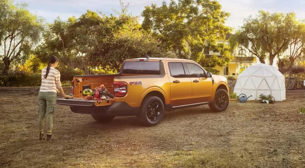 Power tools are shown in the bed of a yellow 2022 Ford Maverick XLT.
