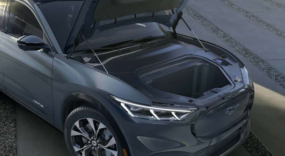 A grey 2023 Ford Mustang Mach-E is shown with the frunk open at a Ford Mach-E dealer.
