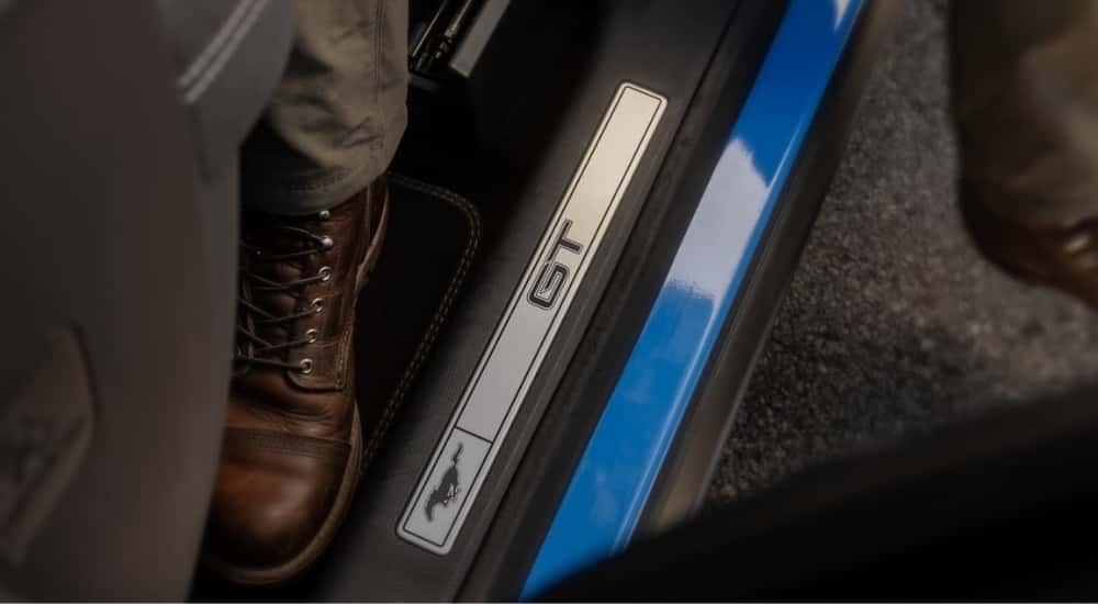 A close-up shows show sill badging on a blue 2023 Ford Mustang Mach-E GT.