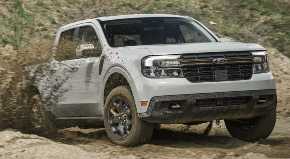 A white 2023 Ford Maverick Tremor is shown off-roading after leaving a Ford Truck dealer.