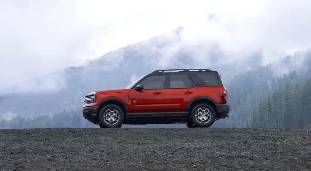 A red 2021 Ford Bronco Sport Badlands is shown overlooking misty mountains.