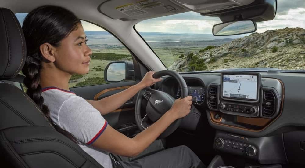 A person is shown driving a 2023 Ford Bronco Sport.