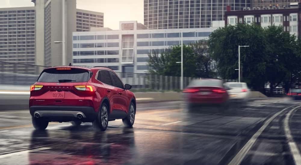 A red 2022 Ford Escape is shown driving on wet pavement.
