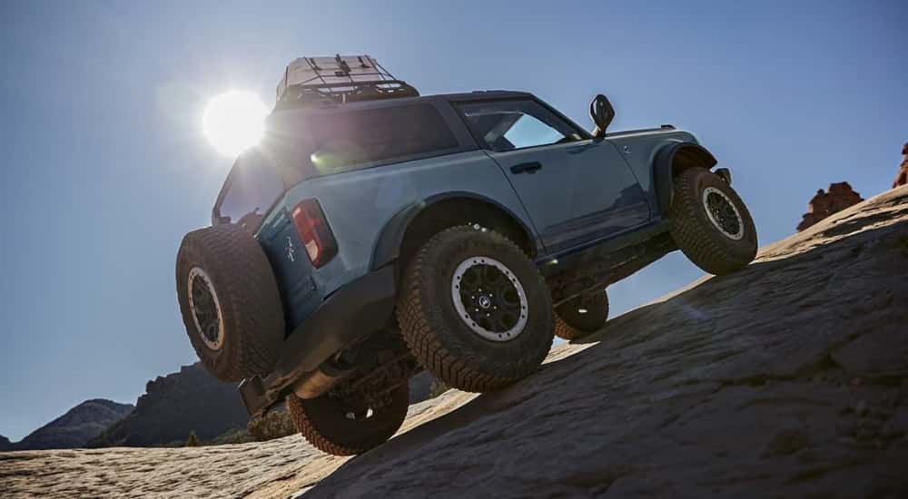 A blue  2024 Ford Bronco Outer Banks is shown off-road.