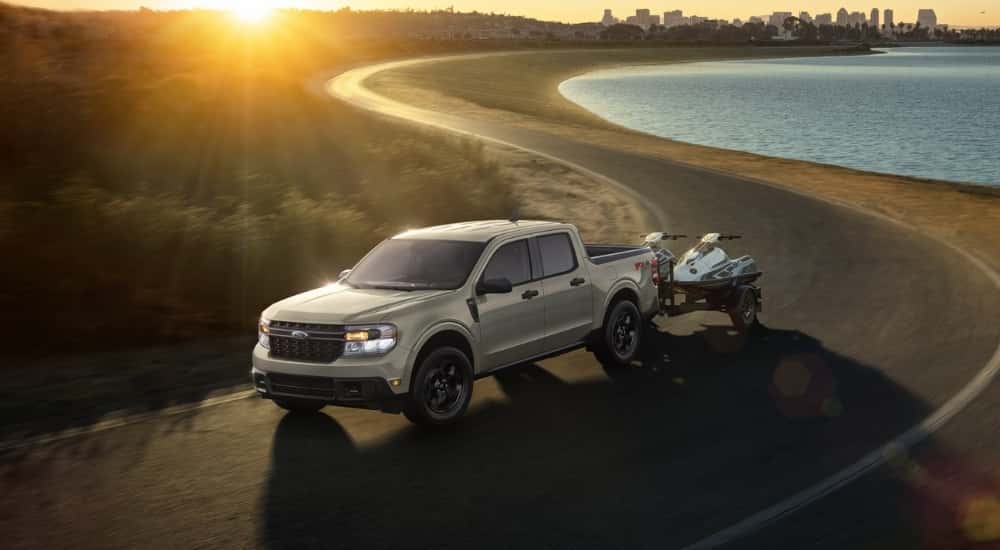A grey 2024 Ford Maverick XLT is shown driving on a coastal road.