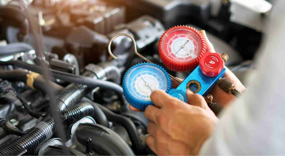 A mechanic checking a vehicle's AC system at an auto repair shop near Stockbridge.