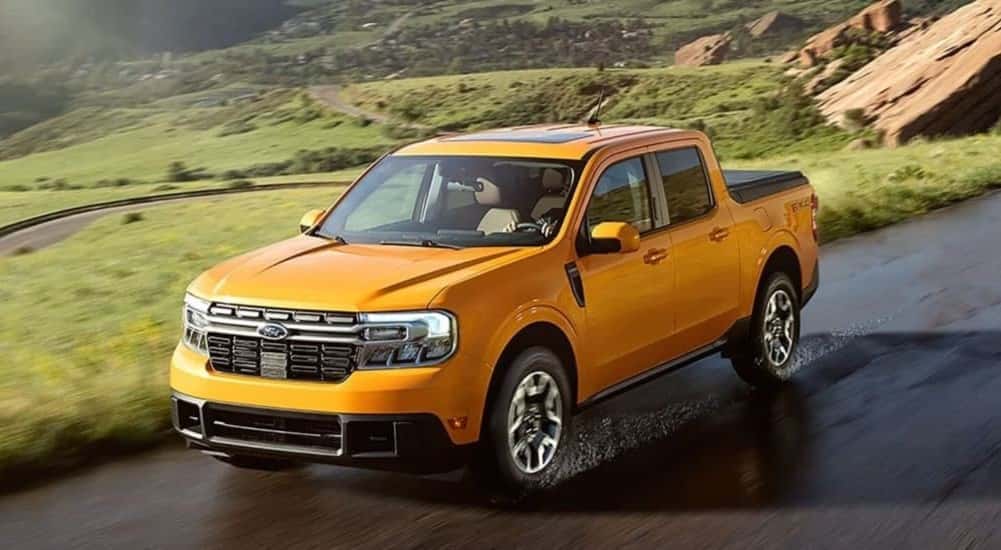 An orange 2024 Ford Maverick is shown driving on a sunny day.