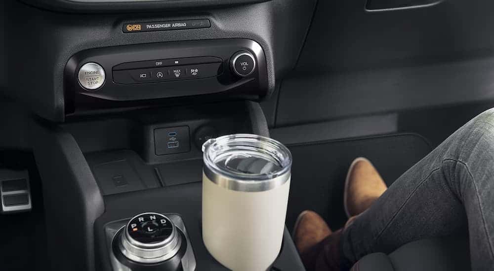 A close up of a coffee cup in the center console of a 2024 Ford Escape.