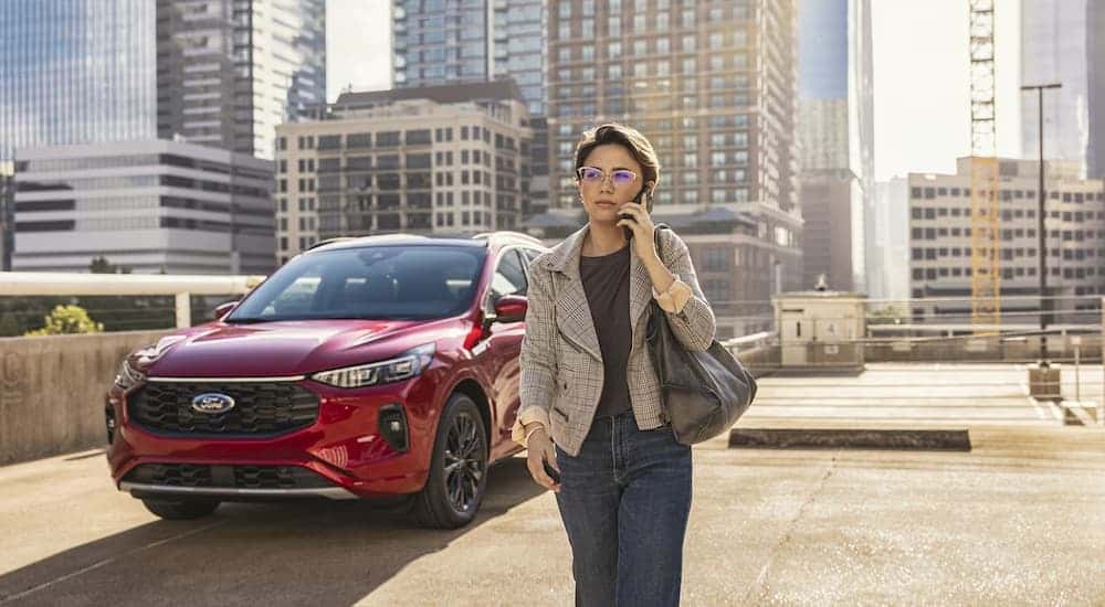 A red 2024 Ford Escape is parked in a rooftop parking lot.