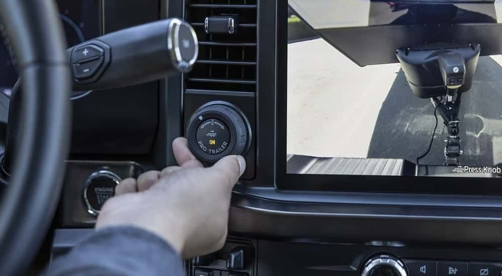 A person is shown using the pro trailer knob in a 2023 Ford F-250.