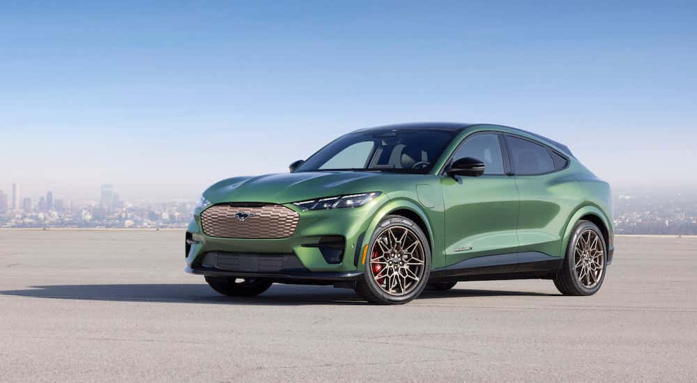 A green 2025 Ford Mustang Mach-E GT is shown from the front at an angle.