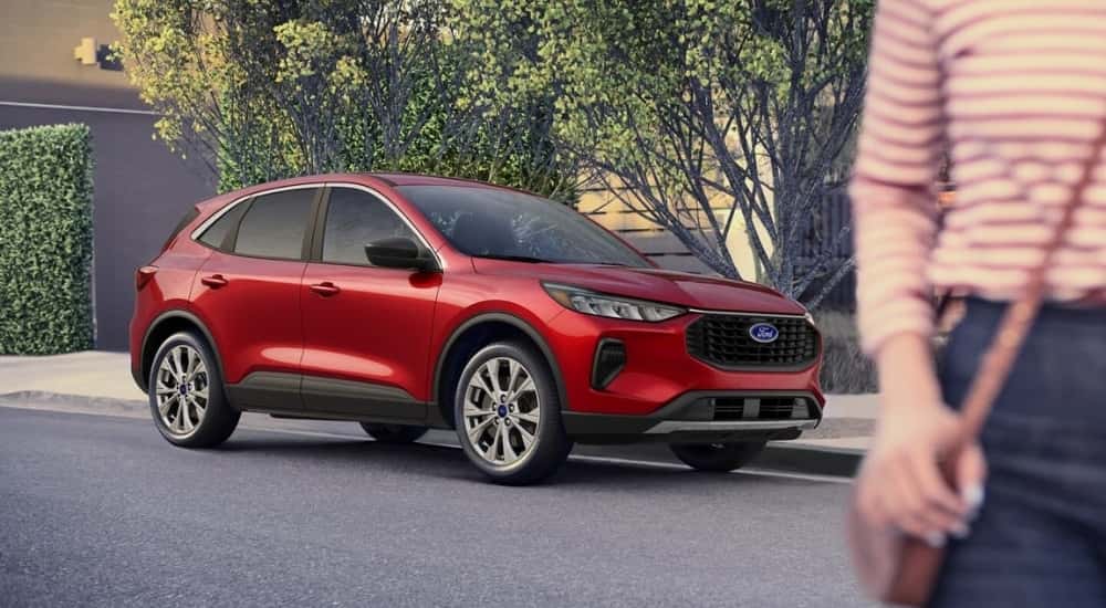 A person is shown walking away from a red 2025 Ford Escape.
