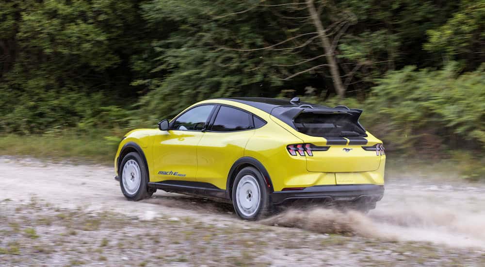 A yellow 2025 Ford Mustang Mach-E Rally is shown from the rear at an angle.