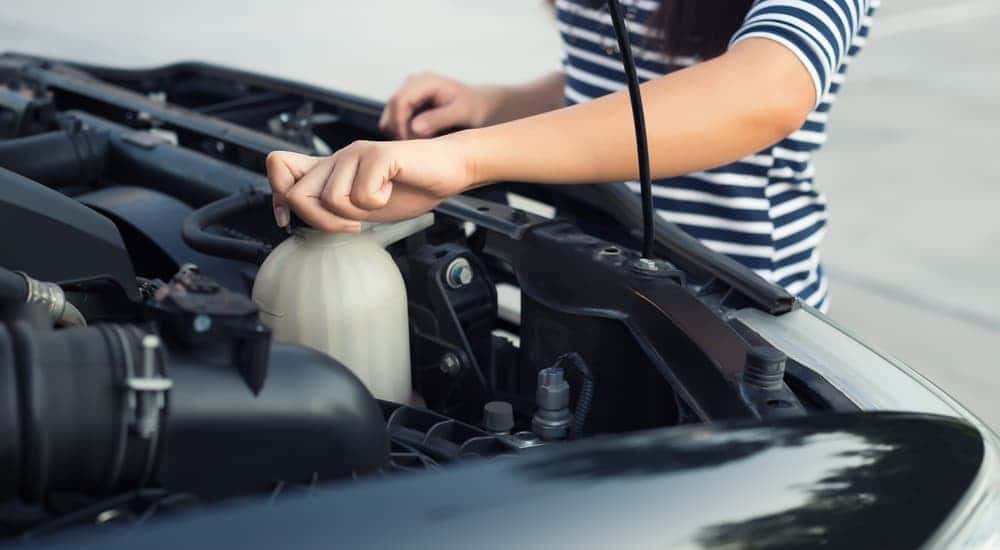 A person is checking the coolant in their car's engine.