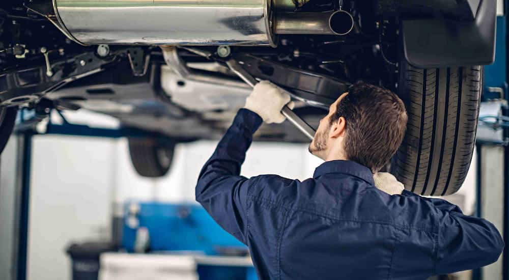 A mechanic near you is shown working on a vehicle on a lift.