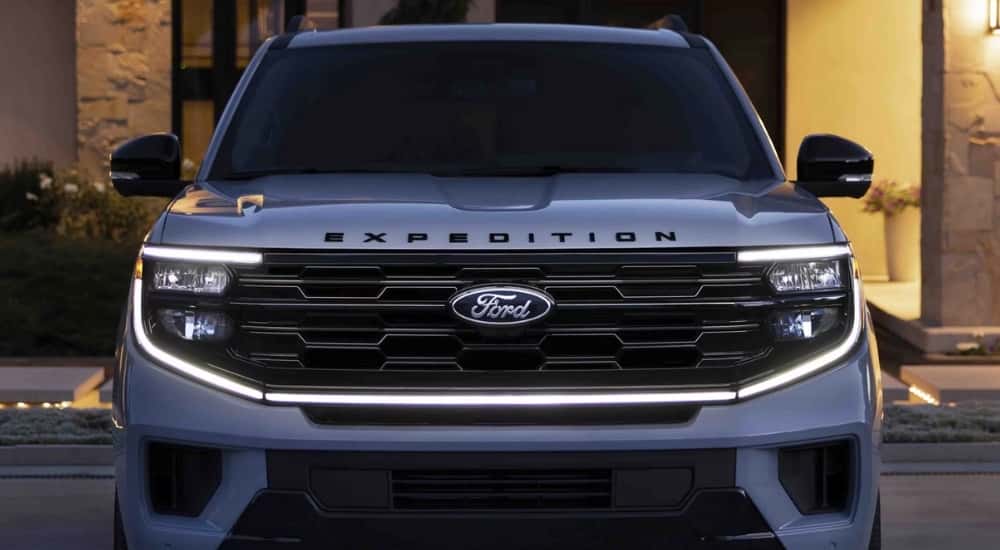 The front view of a grey 2025 Ford Expedition parked outside of a home.