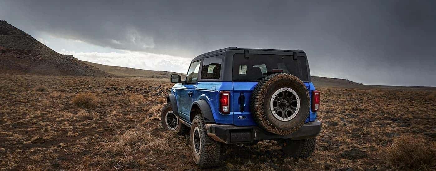 A blue 2023 Ford Bronco Black Diamond is shown from a rear angle overlooking a desert landscape."