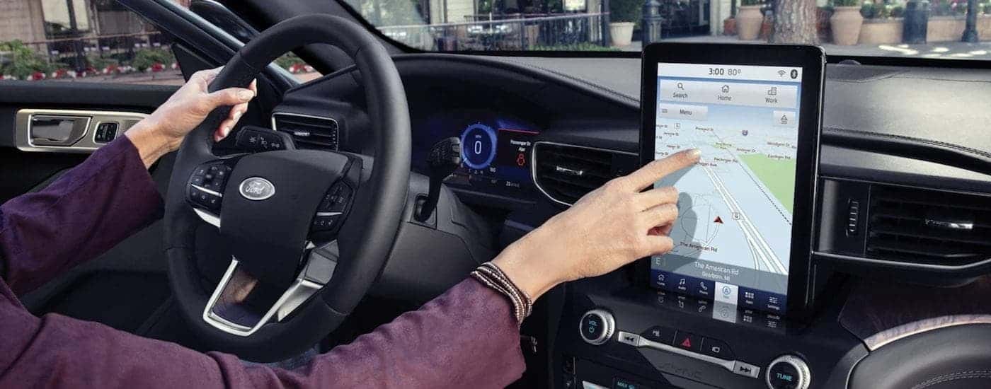 The black interior of a 2023 Ford Explorer shows the infotainment screen.