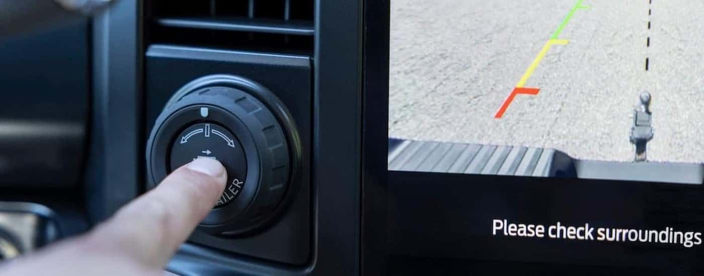 A person is shown pushing the hitch assist button in a 2023 Ford F-250 Ford Super Duty.