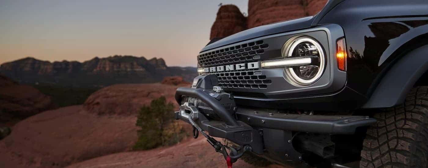 A close up of the front grille of a black 2024 Ford Bronco with a winch accessory.