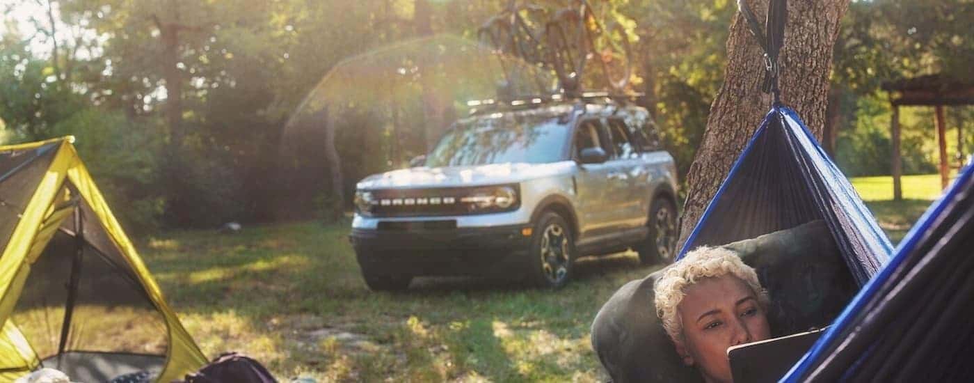 A silver 2024 Ford Bronco Sport is shown parked near a campsite.