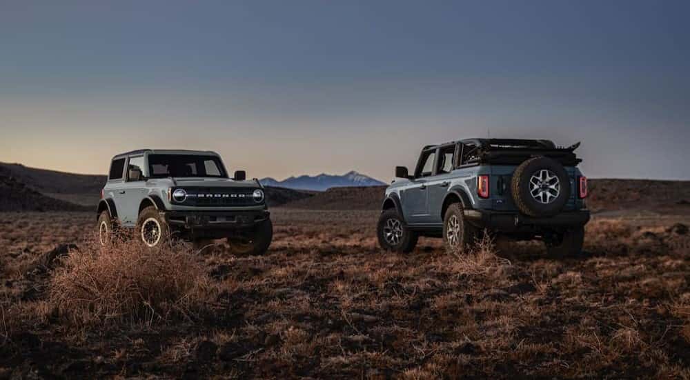 Two blue 2024 Ford Bronco Badlands are shown facing opposite directions.