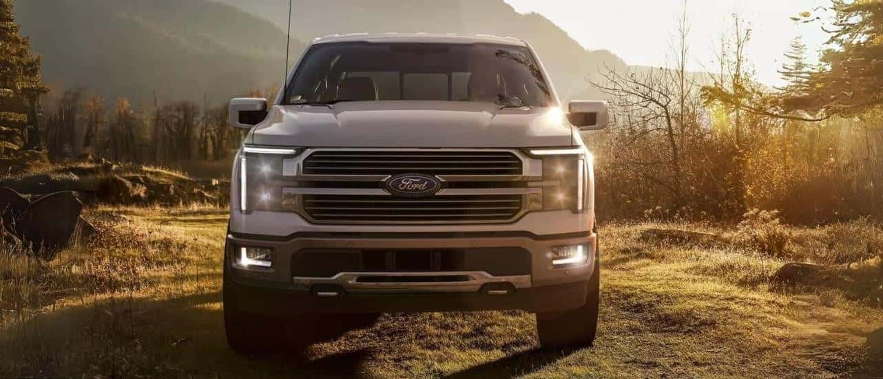 A silver 2024 Ford F-150 King Ranch is shown from the front parked on grass.
