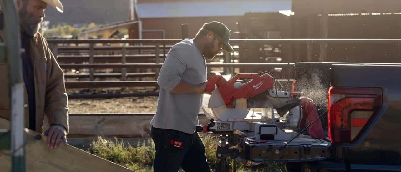 A person is shown using a chop saw on the tailgate of a 2024 Ford F-150.
