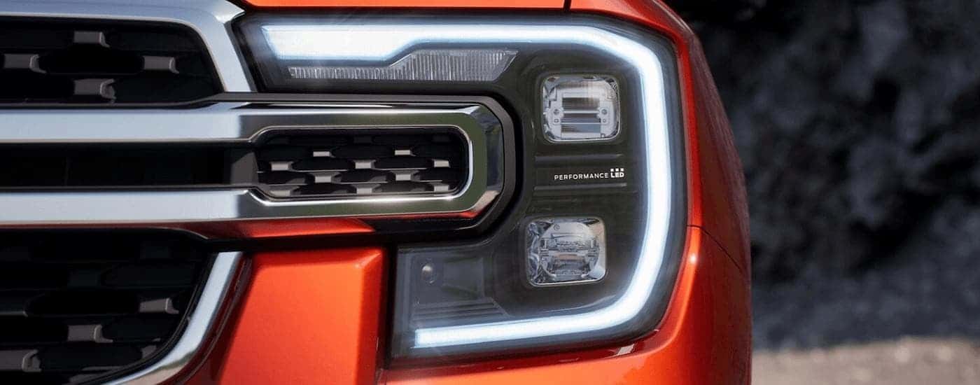 A close up of the headlight on an orange 2024 Ford Ranger is shown.