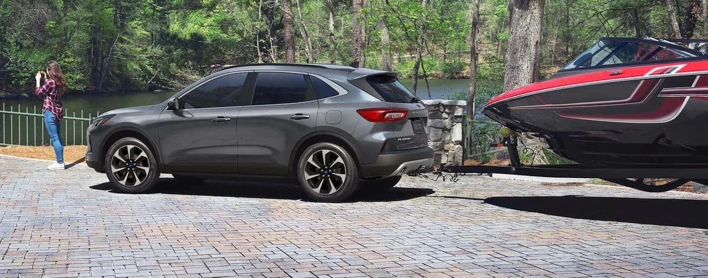 A grey 2025 Ford Escape parked while hitched to a boat.
