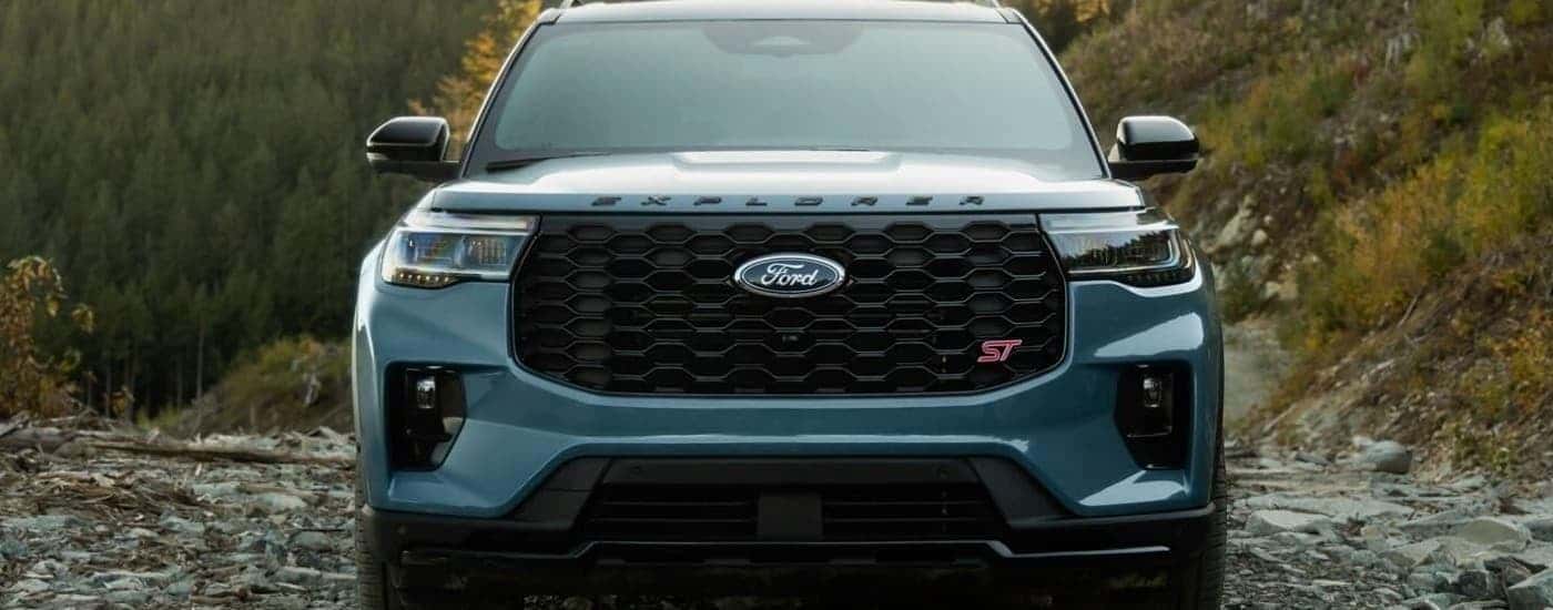 A blue 2025 Ford Explorer ST is parked on a rocky trail.