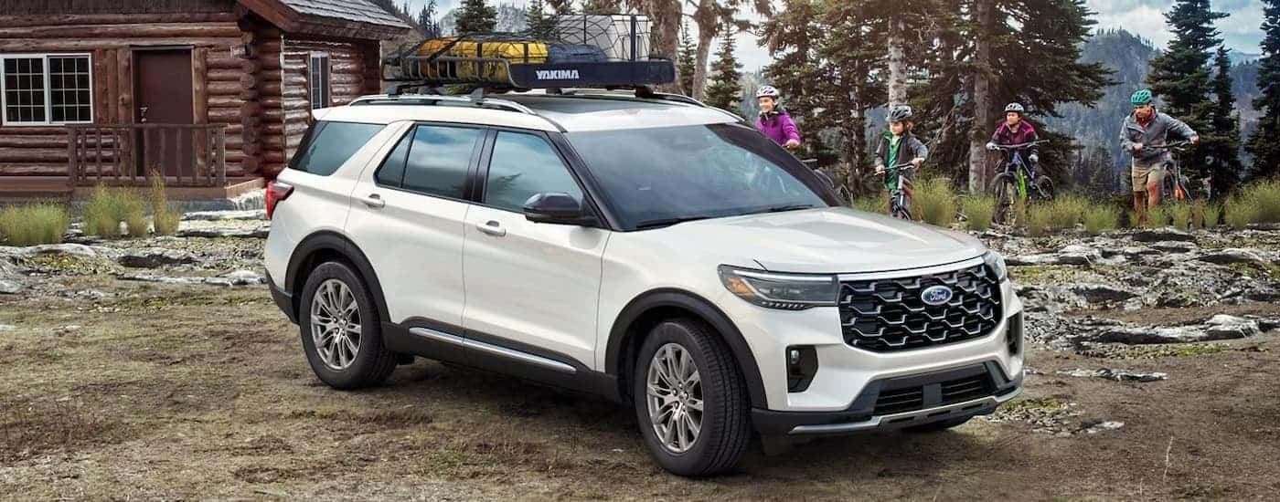 A white 2025 Ford Explorer is parked outside of a cabin.