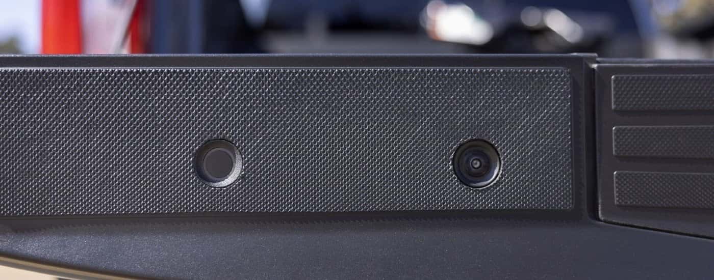 A close-up shows a camera on the tailgate on a grey 2025 Ford F-250.