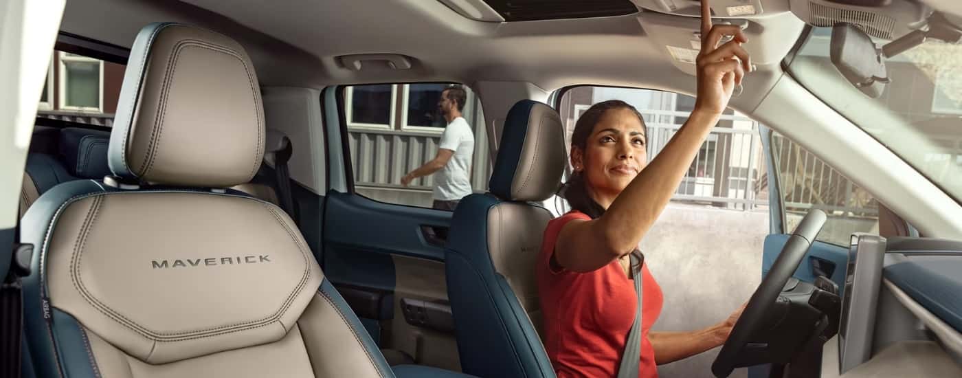A woman is sitting in the driver's seat of a 2025 Ford Maverick Lariat.