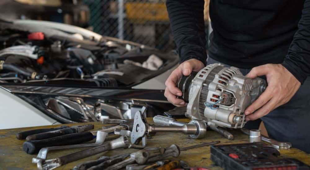 A mechanic working on a car's alternator.