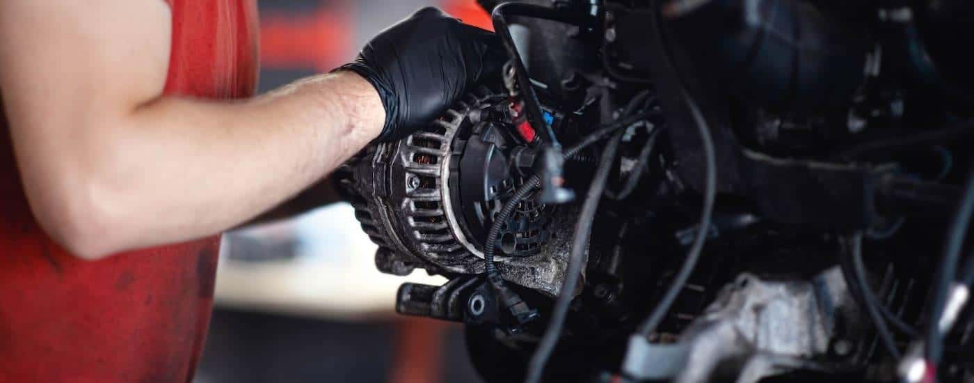 A mechanic performing an alternator replacement in Loganville, GA.