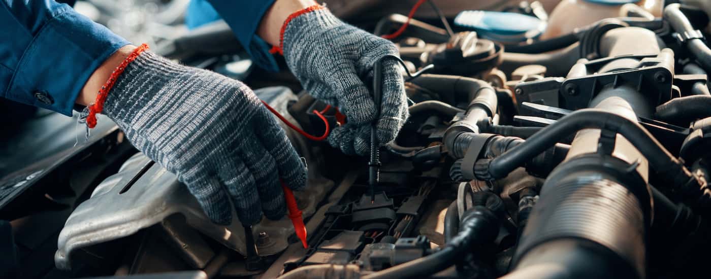 Close-up of a mechanic testing a car battery.