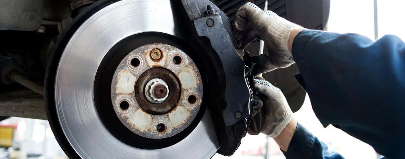 A close up of a mechanic inspecting a set of brakes.
