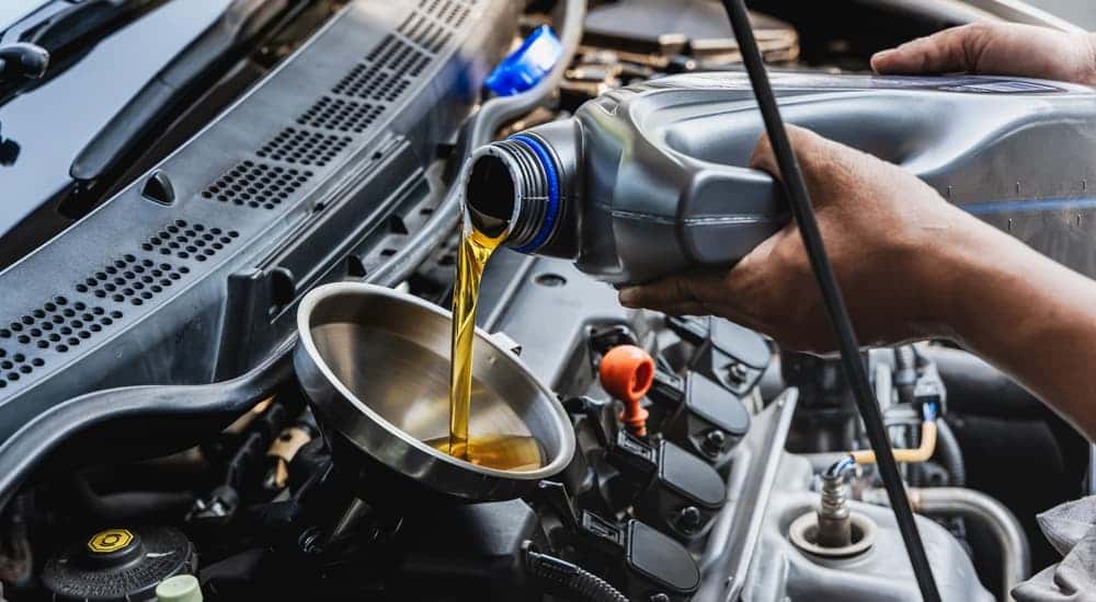 An oil can being poured into a funnel.