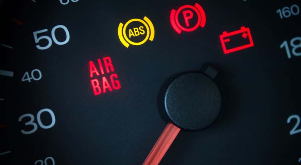 Close-up of multiple warning lights illuminated on the dashboard of a car at an auto repair shop in Loganville.