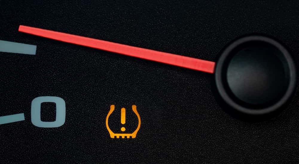 Close-up of a tire pressure sensor light illuminated on a dashboard.