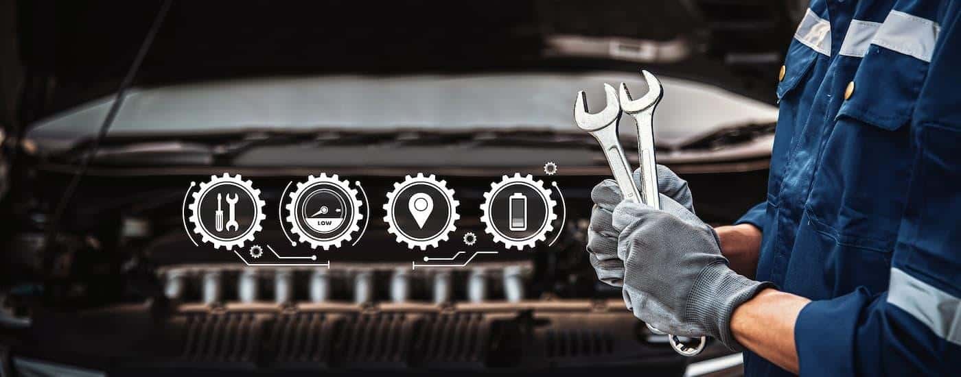 A mechanic is shown holding wrenches next to simulated engine repair symbols.