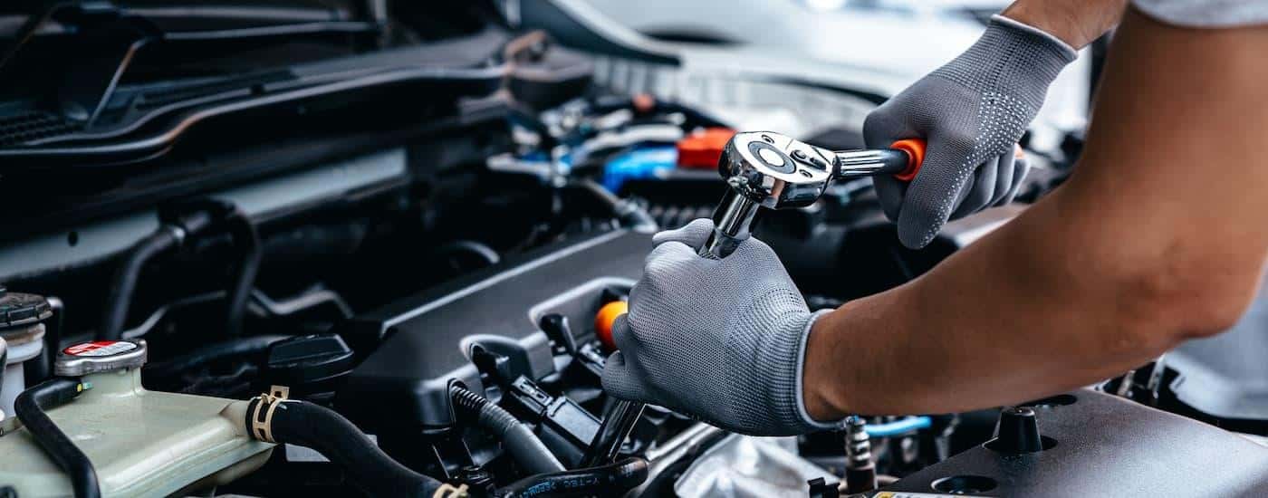 A mechanic is shown working on a vehicle's engine at a repair shop.