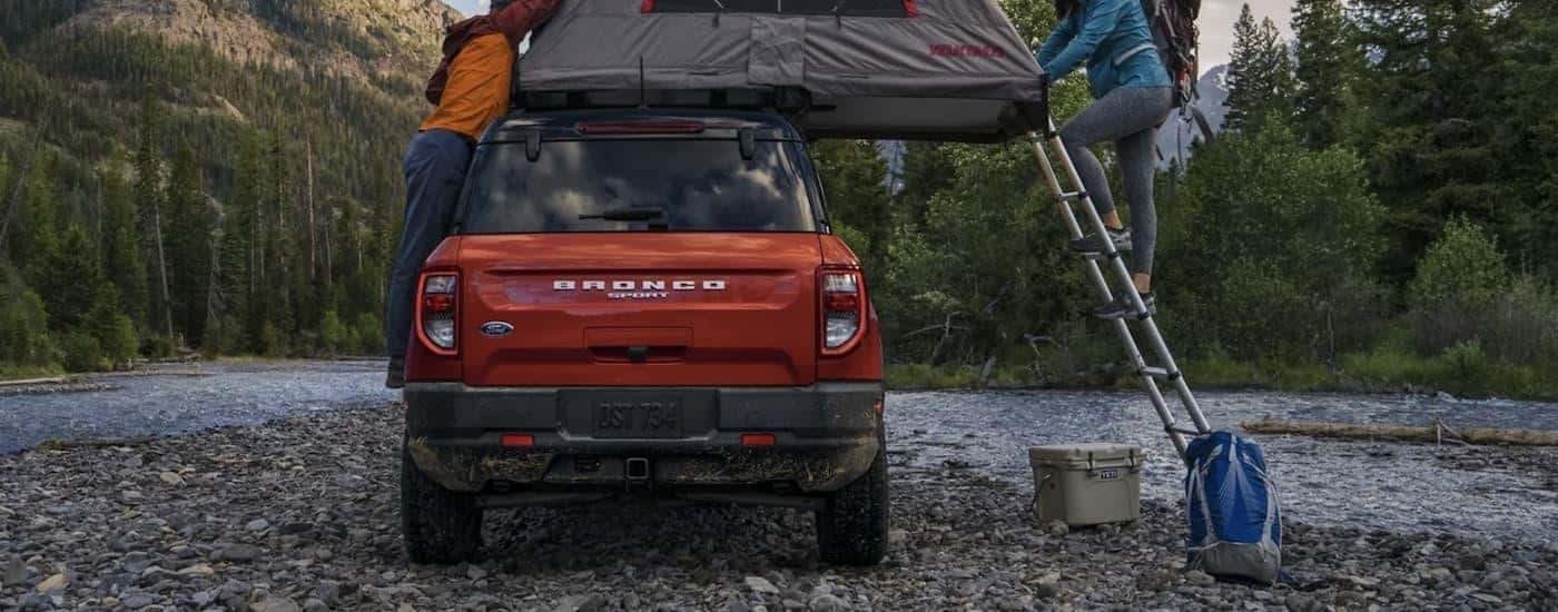 A popular Ford Bronco Sport for sale, a red 2023 Ford Bronco Sport, is shown from the rear parked next to a river.