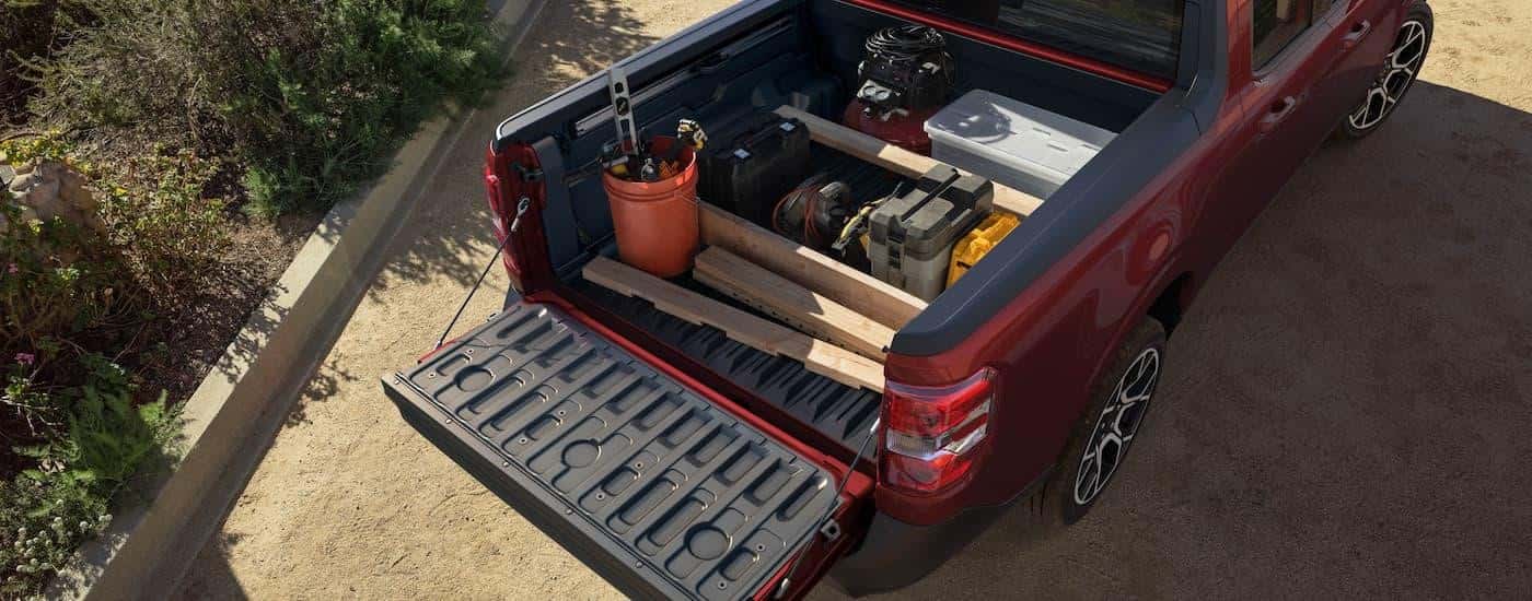 The bed of a 2025 Ford Maverick is full of tools and wood planks.