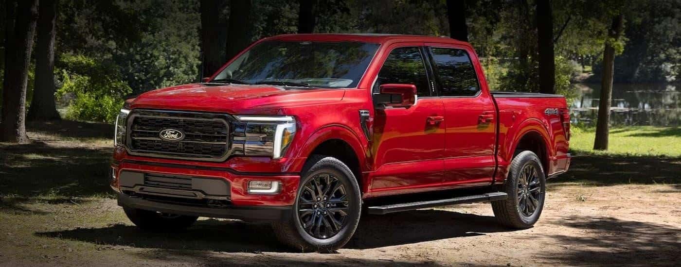 A red 2024 Ford F-150 is shown parked on a dirt road after leaving a Ford dealer near Conley.