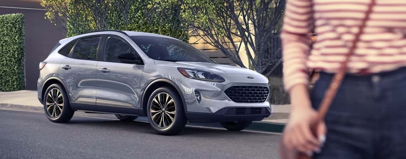 A person is shown walking past a silver 2022 Ford Escape for sale.
